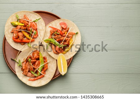 Plate with tasty fresh tacos on color background