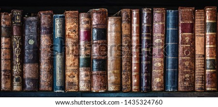 Old books on wooden shelf. Tiled Bookshelf background.  Concept on the theme of history, nostalgia, old age. Retro style. Royalty-Free Stock Photo #1435324760