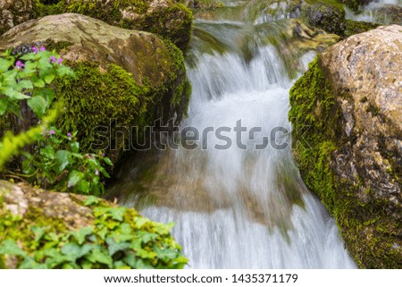 Water runs over rocks in the mountains.