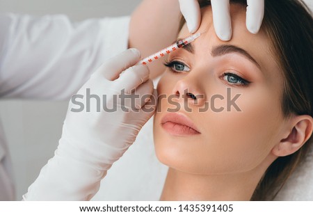 beauty injections into beautiful face. smoothing of mimic wrinkles around the eyes using biorevitalization Royalty-Free Stock Photo #1435391405