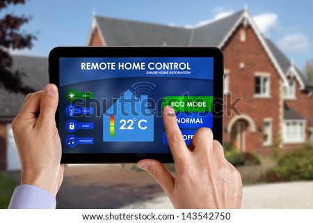 Holding a smart energy controller or remote home control online home automation system on a digital tablet. All screen graphics made up.