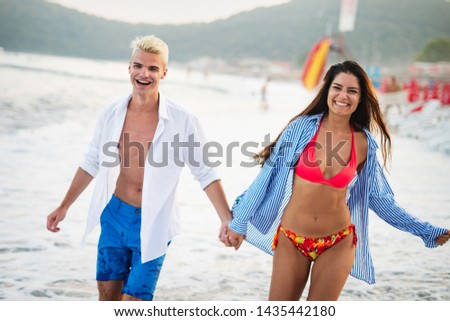 Happy young couple having fun and love at beach on sunny day
