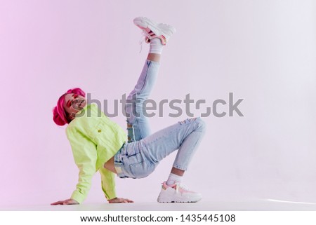 woman with pink hair in ripped jeans with leg raised