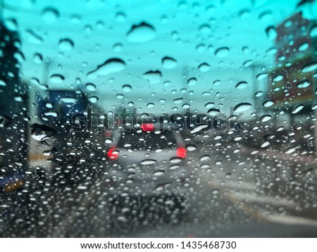 Defocused image, raindrops on windshield, colorful bokeh with street light.