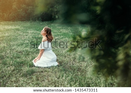 Soft natural beauty portrait of young dreamy woman with blue eyes and  light hair, weared in white dress.Photoshoot in the park in summer sun day.