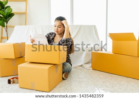 Image of Asian woman,checklist planning investigate enthusiastic packing cardboard box, Moving boxes and household stuff in modern room or Delivery packing, moving boxes at new home for customer Royalty-Free Stock Photo #1435482359