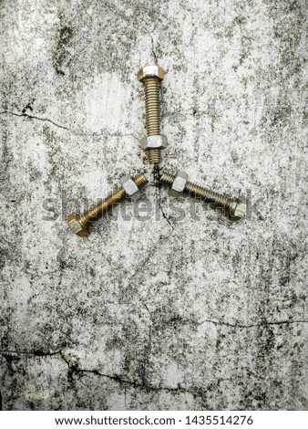 three bolt and nut arranged in star pattern on a cracked dirty industrial workshop background wallpaper