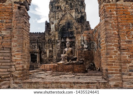 The old castle and the Buddha statue are made of stone. There are many monkeys