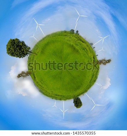 Globe sphre effect Electrical Eco power maker wind turbine in fresh green field against blue sky