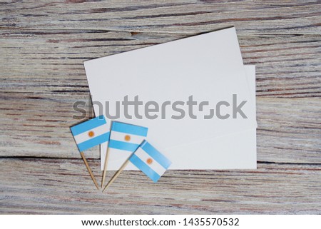 July 9. Independence day of Argentina, Sweden concept of the Day of memory, freedom and patriotism. three mini flags and two sheets of white paper on a wooden white background