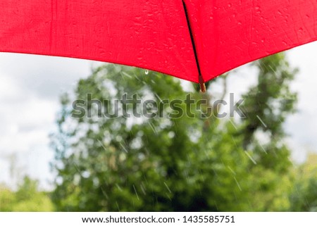 Red umbrella and falling rain drops.