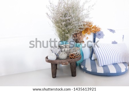 A lot of decorative cozy pillows and the inscription HOME. In the home interior on the bed with a wicker basket and flowers in it. Spring in the home interior. HOME concept