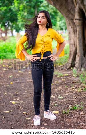 Full length portrait of an Indian girl moving her long hair in air . Healthy hair  of girl.