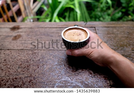 Hot coffee cup on the wooden table nature background in garden, morning rainy day plantations background - Image 