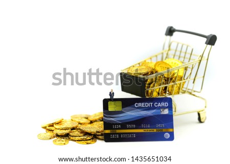 Miniature people : Businessman with Shopping cart,Credit cards and money stacks of coins shopping online business concept.
