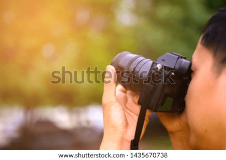 The photographer holds the camera to take pictures.