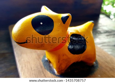 
Little Puppy Bull Terrier. Lovely yellow-black color made of wood, elegant standing, waiting for the boss to play with focus.