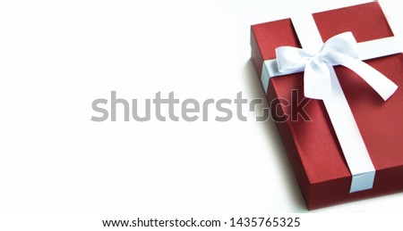 Red gift box with ribbon bow isolated on white background.                             