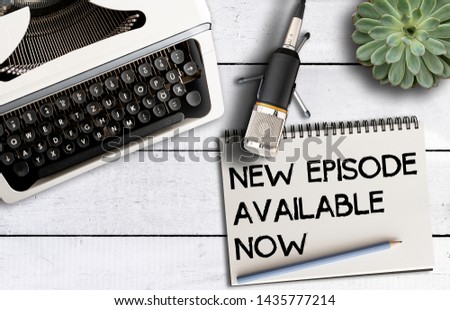 podcast concept, top view of microphone on desk with old typewriter and notepad with text NEW EPISODE AVAILABLE NOW Royalty-Free Stock Photo #1435777214