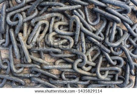 Metal chains - abstract  background. Ships anchor chain lying on the sand wooden deck. Heap of old ship anchor chain links close-up. Grunge Vintage Style Background.