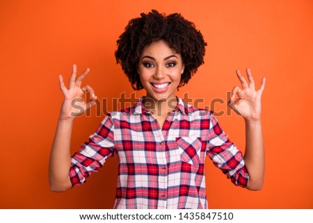 Portrait of lovely cheerful youngster teen have choice decision  excellent promo feedback dressed checked shirt modern clothes isolated orange background