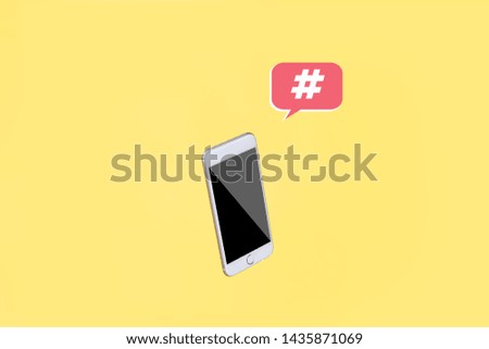 Social Media Marketing Concept Smartphone on Yellow Background with Hashtag Symbol in pink Speech Bubble