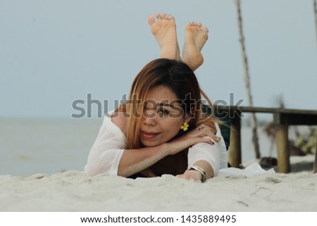 A graceful woman on a beach posing in front of the camera