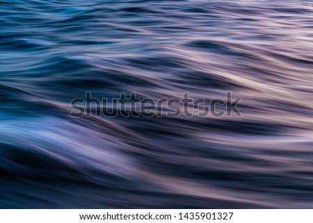 Gentle soothing silky flowing natural ocean water movement. Abstract background motion blur. Serene and peaceful deep blue sea in nature.
