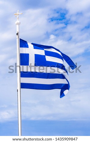 A Greek flag flying against cloudy sky