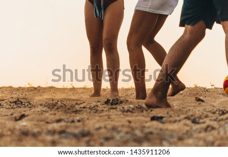 Low section portrait of handsome man playing soccer on the sand beach Royalty-Free Stock Photo #1435911206