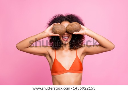 Close up photo beautiful cheer she her dark skin bright lady stylish trendy hands arms hold coconuts hide eyes funny funky pool party chill wear swimming orange suit isolated pink background