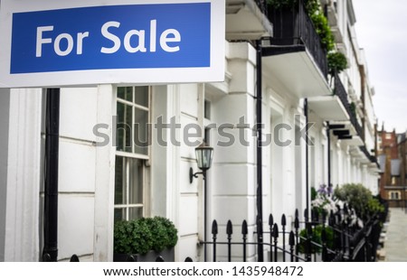 An estate agent 'For Sale' sign on upmarket London street