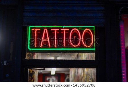 Tattoo neon sign on entrance of the shop