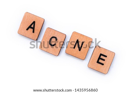 The word ACNE, spelt with wooden letter tiles over a white background. 