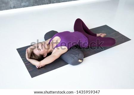 European slim woman practicing yoga lying in Reclined Butterfly exercise relaxing after practice Royalty-Free Stock Photo #1435959347