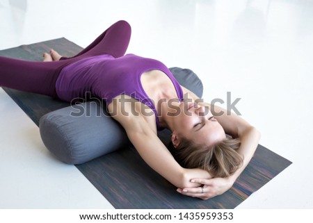 European slim woman practicing yoga lying in Reclined Butterfly exercise relaxing after practice Royalty-Free Stock Photo #1435959353