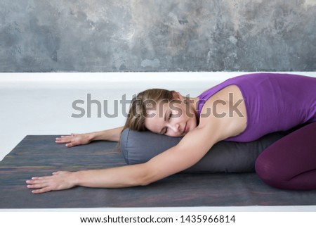 Beautiful slim woman doing yoga exercise for spine and rest lying in Child Pose, Balasana Posture after practice. Full length view Royalty-Free Stock Photo #1435966814