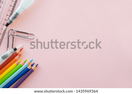 School drawing supplies on pink background. Free space