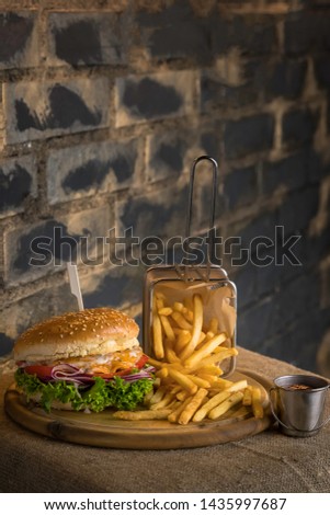 Homemade beef burger with french fries on the dark and brick wall background