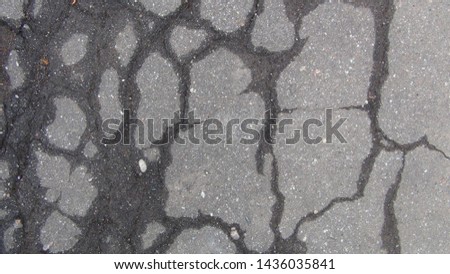 texture and background cracked asphalt into squares after the rain