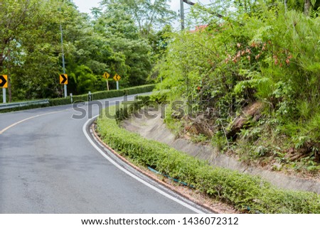Curve in the forest, Bend street up to the mountain, Traffic warning sign label for show that the road curves 