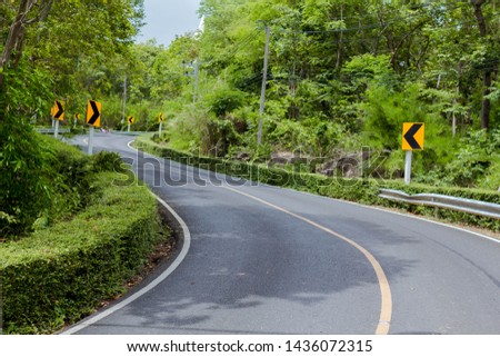 Curve in the forest, Bend street up to the mountain, Traffic warning sign label for show that the road curves 