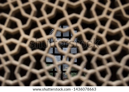 Ancient Indian monument seen through geometric stone lattice