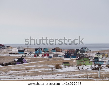 Traditional colored wooden houses at sea, in a snowy landscape, Magdalen islands, Quebec, Canada