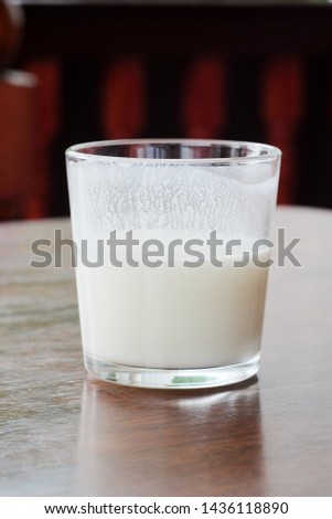 Close up glass of ayran. Traditional oriental turkic sour milk drink in the glass on the table. Kefir