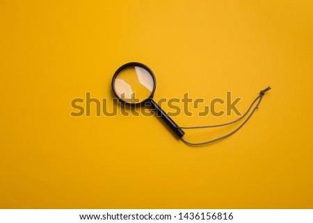 Children magnifying glass on yellow background, search symbol