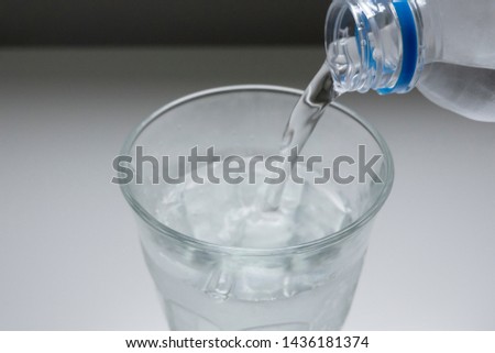 
Image picture pouring plastic bottle of water into glass glass