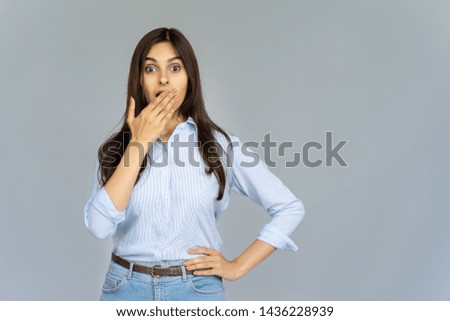 Surprised indian girl student looking at camera covering open mouth with hand isolated on grey studio background with copy space, amazed shocked hindu business woman astonished by shopping sale offer Royalty-Free Stock Photo #1436228939