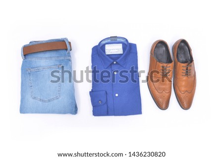 folded cotton shirt and blue jeans with leather shoes isolated on white background


