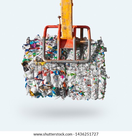 Loader holds big isolated pressed plastic cube of waste ready for recycling   Royalty-Free Stock Photo #1436251727